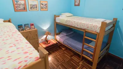 a bedroom with two bunk beds and a ladder at Beraja Family Hostel in Lima