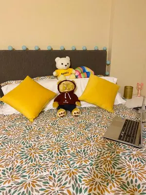 a teddy bear sitting on a bed with a laptop at Sai in Lima
