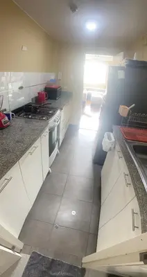 a kitchen with white cabinets and a stove top oven at Sai in Lima