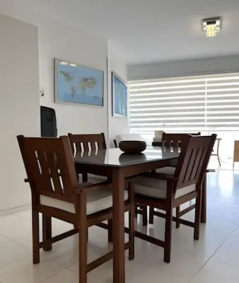 a dining room with a wooden table and chairs at e-t*| Apartamento frente al mar in Cerro Azul