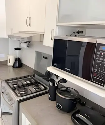a kitchen with a stove and a microwave at e-t*| Apartamento frente al mar in Cerro Azul