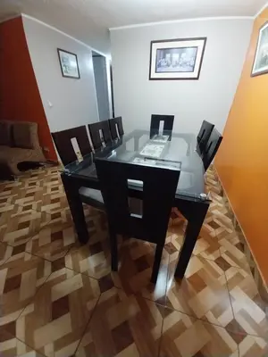 a black table and chairs in a room at Amplio Departamento amoblado, Condominio Parques de la Huaca - San Miguel in Lima