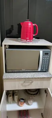 a microwave with a red mug on top of it at Warmisitay Mini departamento in Lima