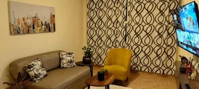 a living room with a couch and a tv at Warmisitay Mini departamento in Lima