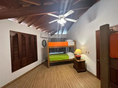 a bedroom with a ceiling fan and a bunk bed at Casa de Campo Condominio El Pueblo-Santa Clara,Ate in Lima