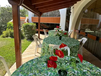 a table and chairs with red flowers on a patio at Casa de Campo Condominio El Pueblo-Santa Clara,Ate in Lima