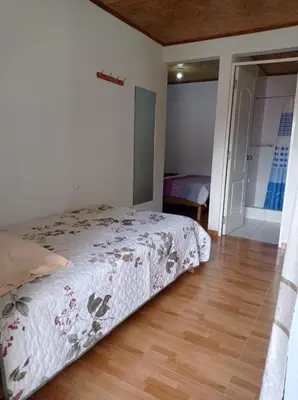 a bedroom with a bed and a wooden floor at Hospedaje Casablanca in Pozuzo