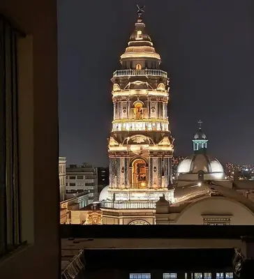 a tall building with a clock tower at night at Departamento frente a palacio gobierno in Lima