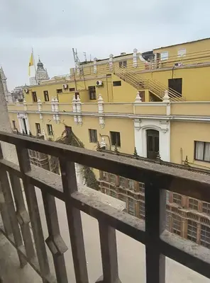 a view of a building from behind a fence at Departamento frente a palacio gobierno in Lima