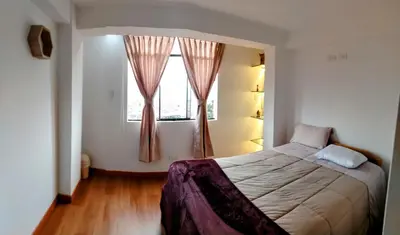 a bedroom with a large bed and a window at Panoramic Cusco in Cusco