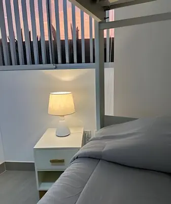 a bed with a lamp on a night stand next to a bunk bed at Condominio Ocean reef in San Bartolo