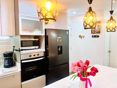 a kitchen with a black refrigerator and a vase of flowers at Pacific apartamento Miraflores in Lima
