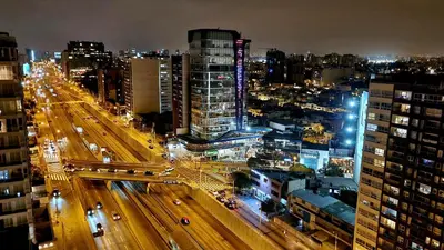 a city at night with cars on a highway at Habitación con Baño privado en Departamento Compartido in Lima