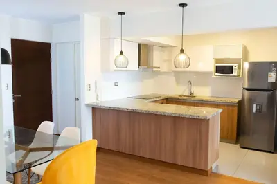 a kitchen with a stainless steel refrigerator and a table at Comfort and Space 3bed and 2 and haf bath centric location in Lima