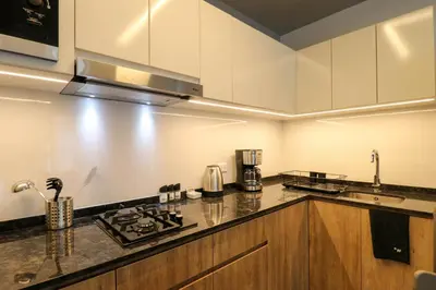 a kitchen with white cabinets and a stove top oven at Living 110 Suites by Wynwood House in Lima