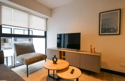 a living room with a television and a chair at Living 110 Suites by Wynwood House in Lima