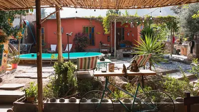 a backyard with a pool and a table and chairs at Soy y Luna- ECOALBERGUE RETABLOS PERU in Lunahuaná