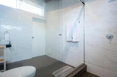 a bathroom with a glass shower with a toilet at Private Residences by Vibrant in Lima