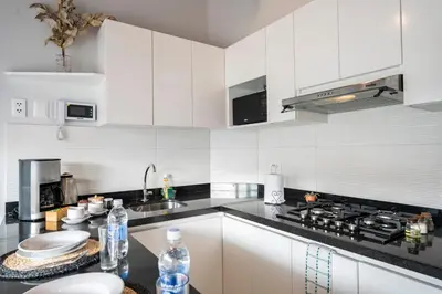 a kitchen with white cabinets and a black counter top at Private Residences by Vibrant in Lima