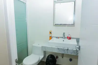 a white bathroom with a sink and a mirror at 1 Habitación en Apto de 2 habitaciones en Centro Financiero San Isidro in Lima