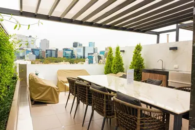 a balcony with a table and chairs and a view of the city at 1 Habitación en Apto de 2 habitaciones en Centro Financiero San Isidro in Lima
