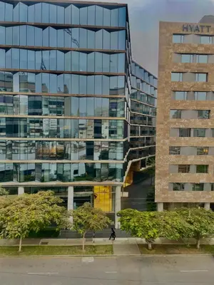 a tall glass building with people walking in front of it at Loft en el centro de San Isidro Pet Friendly in Lima