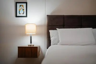 a bedroom with a bed and a lamp on a night stand at Family-Friendly 2BR in Prime Location in Lima