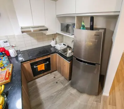 a kitchen with a stainless steel refrigerator and a sink at Apartamento completo en Barranco in Lima