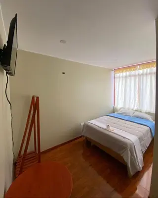 a small bedroom with a bed and a window at LagunaNegra Oxapampa in Palmira