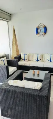 a living room with wicker chairs and a couch at Condominio Nautico Paracas in Ica