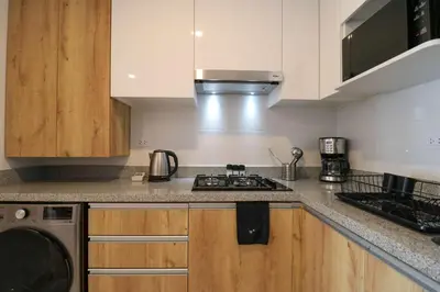 a kitchen with wooden cabinets and a stove top oven at Barron by Wynwood House in Lima