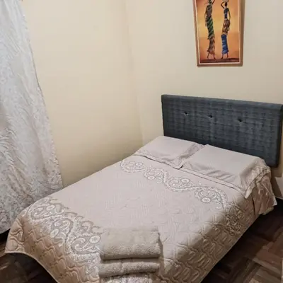 a small bed in a bedroom with a picture on the wall at Hospedaje Rochi House - Cusco- En el Corazón del Cusco in Cusco