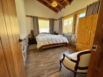 a bedroom with a bed and a chair in it at casa de campo con jaccuzi in Huaran