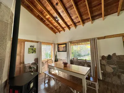 a living room with a table and a fireplace at casa de campo con jaccuzi in Huaran