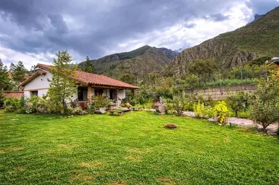 a yard with a house in the mountains at casa de campo con jaccuzi in Huaran