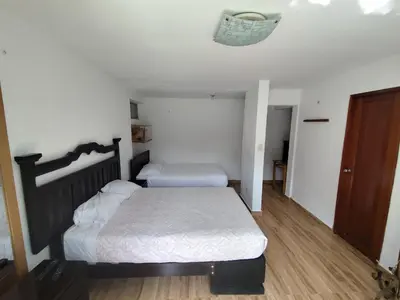 a bedroom with two beds and a ceiling at Casa Campo Isabel Quinteros in Chaclacayo