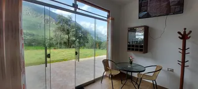 a dining room with a table and chairs and a large window at HOTEL HUAYTARA CasaBlanca in Huaytará