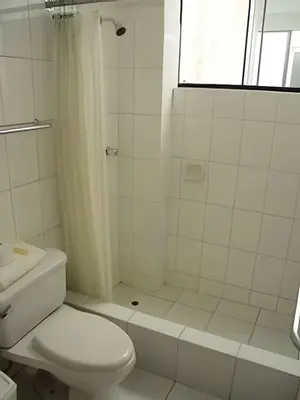 a white bathroom with a toilet and a shower at Incasol Tower 