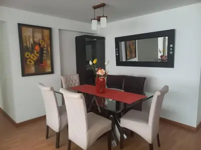 a dining room with a black table and white chairs at Depa El Polo, Embajada USA, Surco in Lima