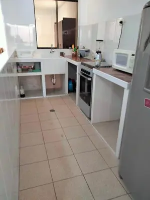 a kitchen with white cabinets and a tile floor at Departamento Pisco - San Andrés, cerca a Paracas in Gallinazos Hacienda