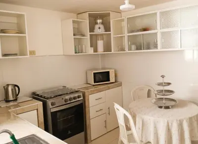 a small kitchen with a table and a microwave at Departamento Pisco - San Andrés, cerca a Paracas in Gallinazos Hacienda