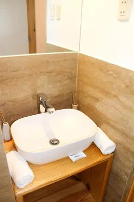 a bathroom with a white sink and a mirror at Suites Machupicchu in Machu Picchu