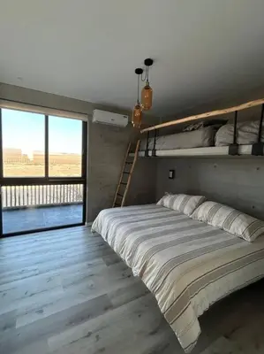 a bedroom with a bunk bed and a staircase at Aldea Bayfront Heaven Paracas in Paracas