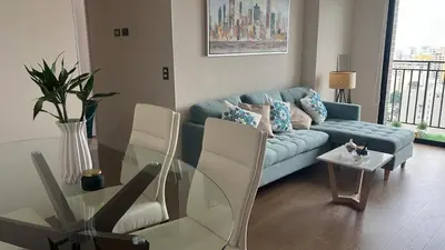 a living room with a blue couch and a glass table at Deluxe Aparment San Isidro in Lima