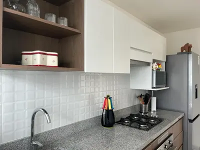 a kitchen with white cabinets and a stove top oven at Deluxe Aparment San Isidro in Lima