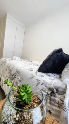 a plant in a glass bowl on a table next to a bed at Hermoso departamento in Lima