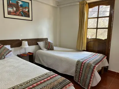 a bedroom with two beds and a window at Tambo Real Valle Sagrado in Yucay