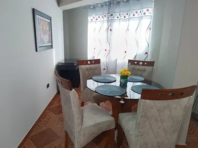 a dining room with a table and chairs and a window at departamento airport in Lima