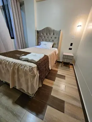 a small bedroom with a bed and a wooden floor at Hotel Sumac Samari in Puquio