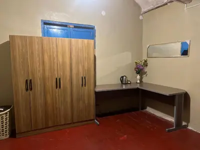 a room with a desk and a wooden cabinet at Habitación con recojo desde el aereopuerto in Cusco
